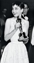 Audrey Hepburn alla cerimonia di premiazione degli Academy Awards nel 1954, dove vinse come Miglior Attrice Protagonista per "Vacanze Romane". Per l'occasione, l'attrice indossò un abito bianco a ricami floreali firmato Givenchy.